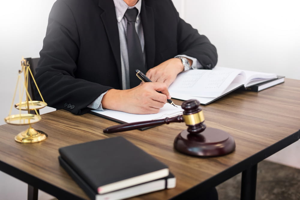 Travail de rédaction juridique sur un bureau d'avocat à Belley avec marteau de justice et balance