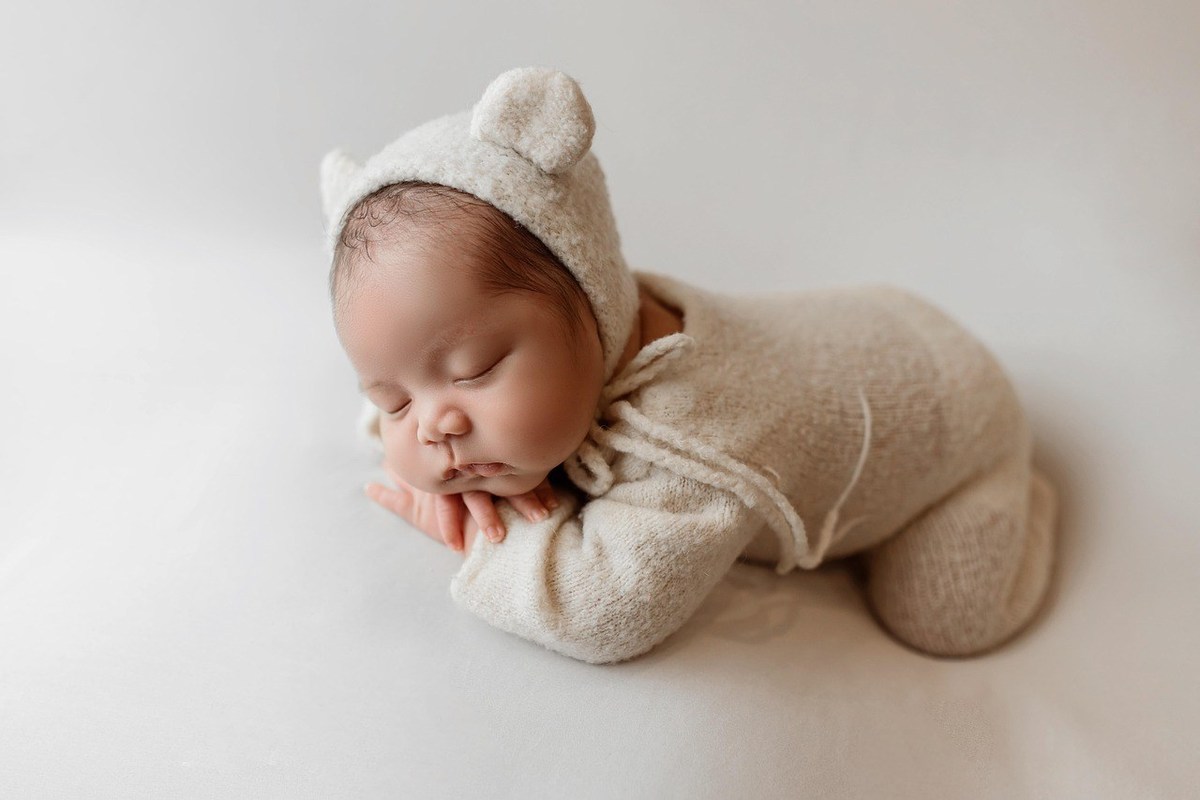 Bébé endormi dans un costume animalier sur fond blanc Bébé endormi dans un costume animalier sur fond blanc