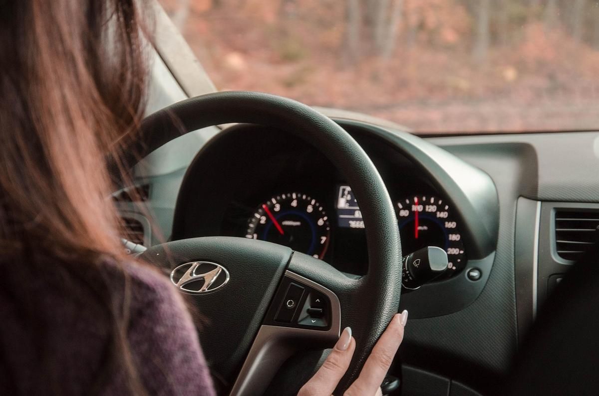 Une femme conduit une Hyundai main sur le volant tableau de bord visible Une femme conduit une Hyundai main sur le volant tableau de bord visible